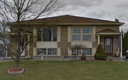 a large brick house with a yard and a tree